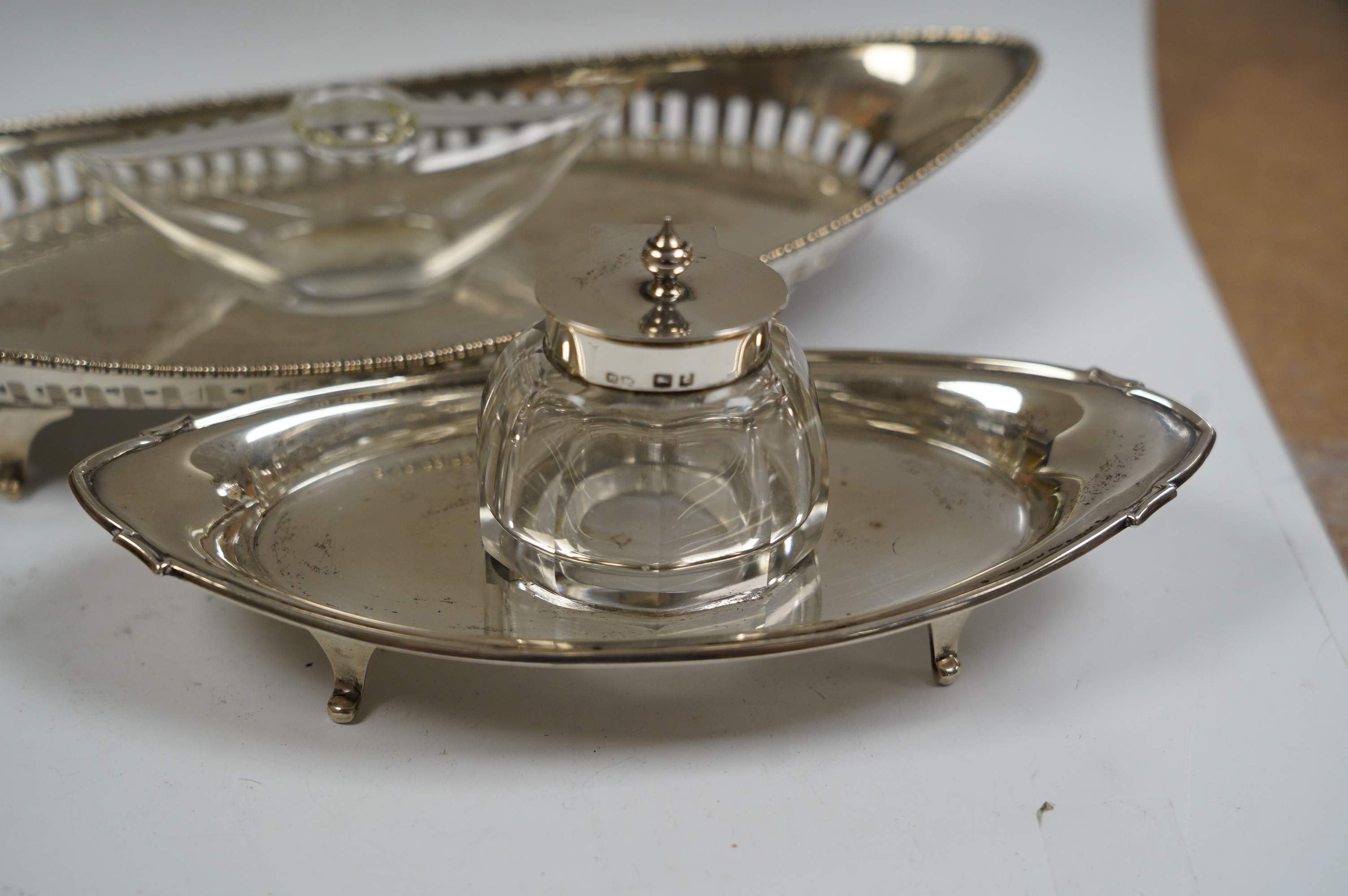 Two George V silver navette shaped inkstands, both with mounted single glass wells, longest 23.8cm, 5.6oz. Condition - fair